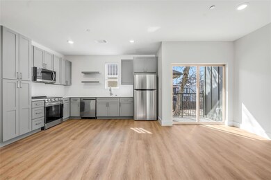 Kitchen with gray cabinetry, a sink, open shelves,