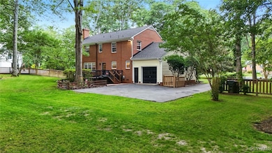 Back of house with a chimney, brick siding, a deck