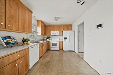 Kitchen featuring white appliances, sink, and light tile floors