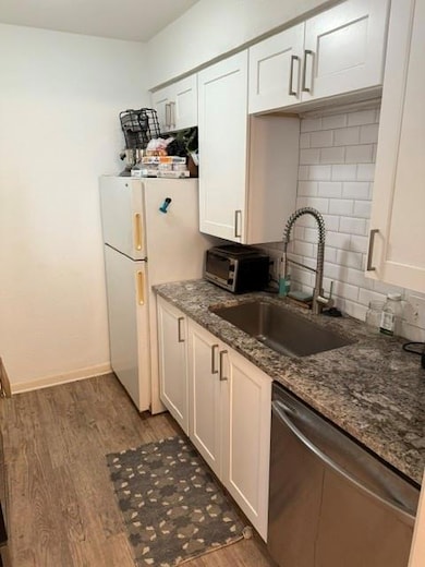 Kitchen with dishwasher, wood finished floors, fr