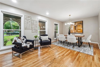 Dining space with light wood-type flooring, baseboards, a chandelier, and recessed lighting