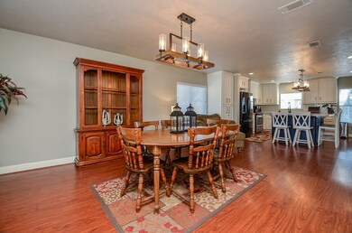 Beautiful dining area with wood flooring and updated lighting, seamlessly connected to the open floor plan