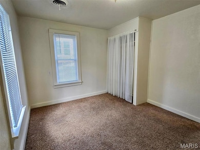Carpeted empty room with baseboards
