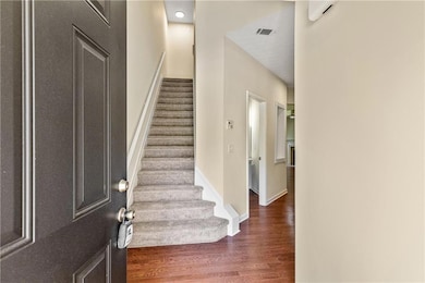 Entryway featuring baseboards, visible vents, dark