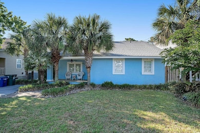 View of front facade with covered porch, a ceiling fan, stucco siding, a front lawn, and roof with shingles