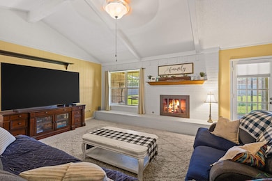 Carpeted living room featuring a brick fireplace, 