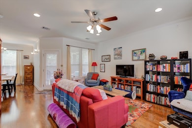 Living room with ornamental molding, a ceiling fa