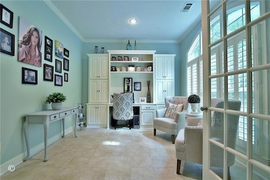 Office area with crown molding and light tile patterned floors