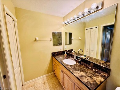 Bathroom with vanity, light tile patterned floors, and a textured ceiling