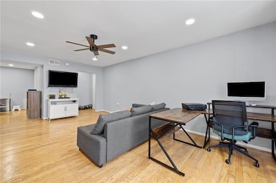 Living area with a ceiling fan, light wood-style floors, recessed lighting, and baseboards