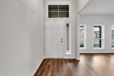 Entrance foyer with dark wood-style floors and baseboards