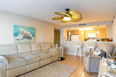 Living area with visible vents, ceiling fan, baseb