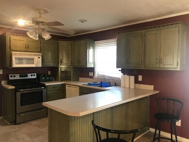Updated kitchen with newer fridge and stove. Bar counter for seating and eat in dining area.