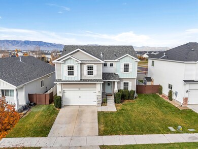 Traditional-style house featuring board and batten siding, an attached garage, concrete driveway, a mountain view, and a residential view