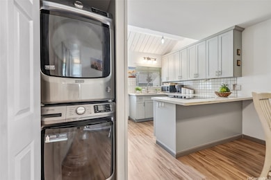 A bright kitchen view with convenient washer and dryer tucked neatly behind a closet for a clean, uncluttered look.