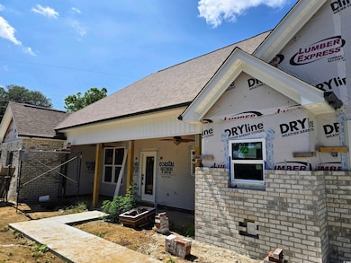 Property under construction featuring roof with shingles and brick siding