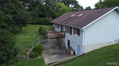 Back of property with a yard, roof with shingles, a patio, and a wooden deck