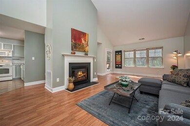 Living room with natural gas log fireplace and vaulted ceiling