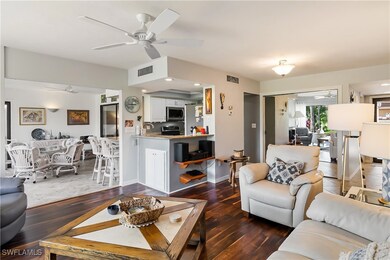 Living room with ceiling fan and dark hardwood / w