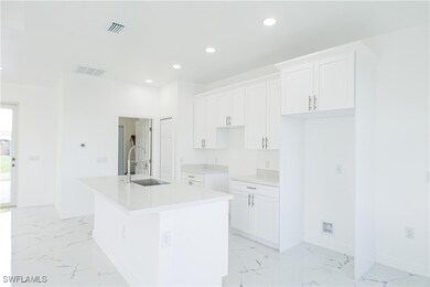 Kitchen with a center island with sink, sink, and
