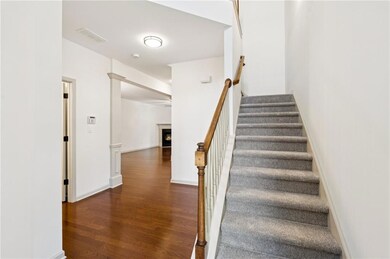 Stairway featuring wood finished floors and a warm lit fireplace