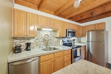 Kitchen featuring stainless steel appliances, back