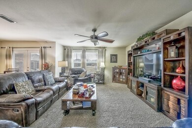 Living room with french doors, ceiling fan, carpet