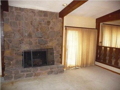 Main floor living room with fireplace and vaulted 