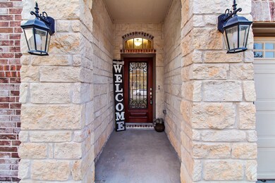 Stone and brick elevation with lantern lights detailing the front entrance.