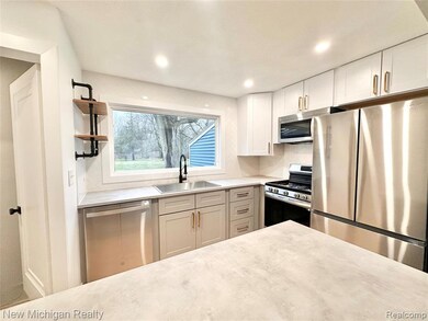 Kitchen featuring stainless steel appliances, tasteful backsplash, open shelves, light stone countertops, and recessed lighting