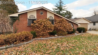 View of side of property featuring brick siding, an attached garage, and driveway