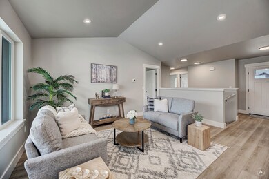 Living room featuring wood finished floors, lofted ceiling, and recessed lighting