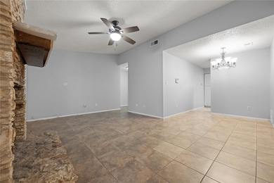Unfurnished living room featuring ceiling fan wit