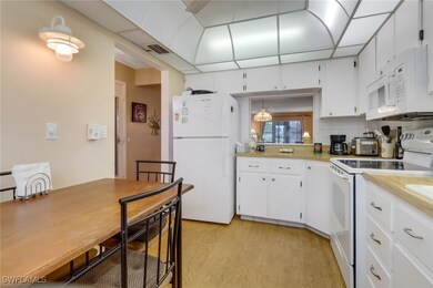 Kitchen featuring unique lighting, white appliance