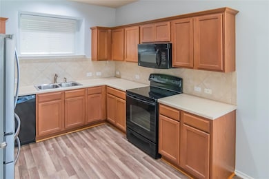 Kitchen featuring black appliances, a sink, decor