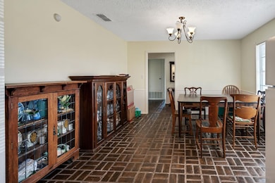 Dining area with a textured ceiling and an invitin