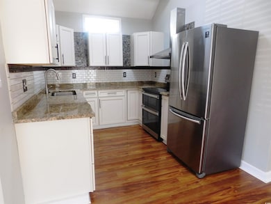 Kitchen featuring a sink, backsplash, appliances w