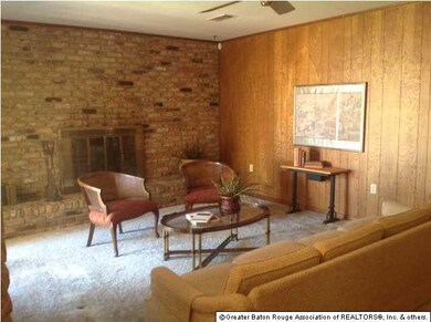 Den with brick wall and fireplace