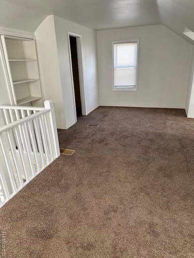 Additional living space with carpet flooring and lofted ceiling