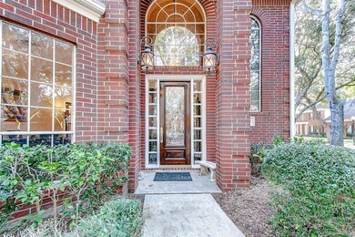 Beautiful entrance has glass and wood front door w
