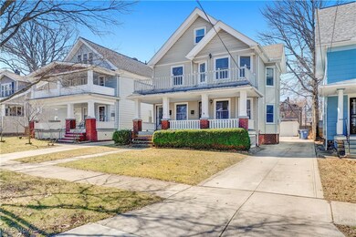 Virtually Staged View of front of house with a front yard, covered porch, a garage, a balcony, and driveway