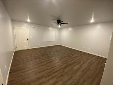 Unfurnished room with dark wood-type flooring and a ceiling fan