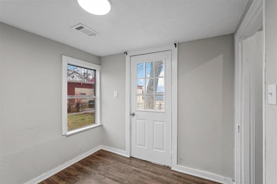 Doorway to outside with dark wood finished floors,
