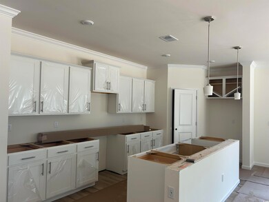 Kitchen with a center island, ornamental molding, and decorative light fixtures