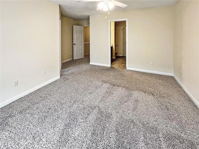Unfurnished bedroom featuring carpet floors, connected bathroom, and a ceiling fan