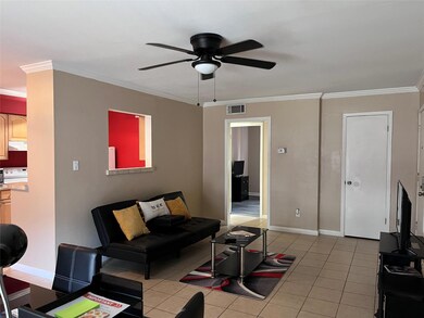 Living room with ceiling fan, crown molding, and l