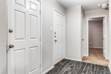 Corridor featuring dark carpet