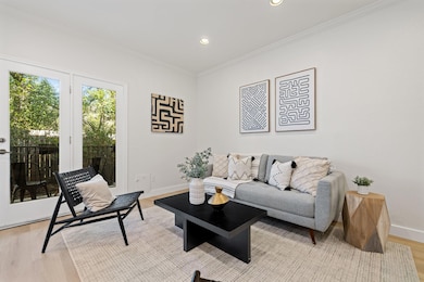 Living area featuring light wood-style floors, ornamental molding, and recessed lighting
