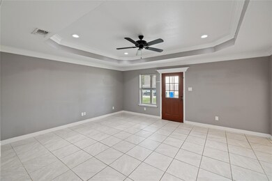 Unfurnished room featuring a tray ceiling, crown molding, and ceiling fan