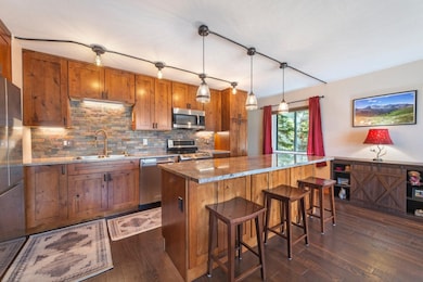 Kitchen featuring brown cabinetry, a kitchen island, decorative backsplash, and appliances with stainless steel finishes